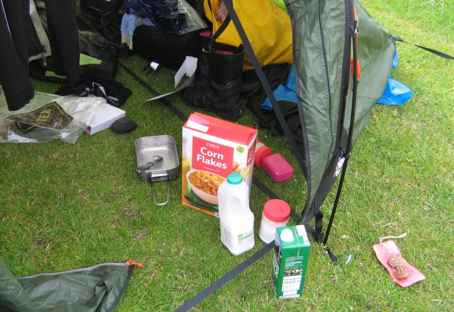 cornflakes box, billy can and general camping stuff in the tent entrance